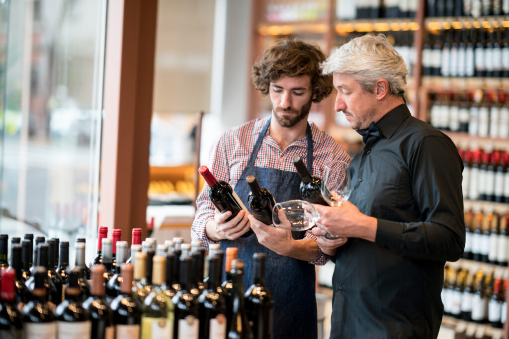 Liquor store, owner choosing wine for business