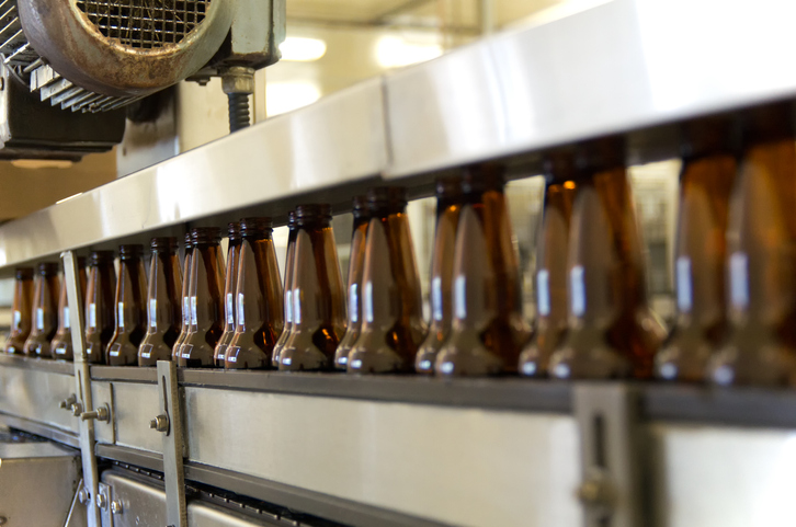 Types of Liquor Licenses: Liquor Manufacturing/Class E. Image: Beer bottles on a factory's production belt