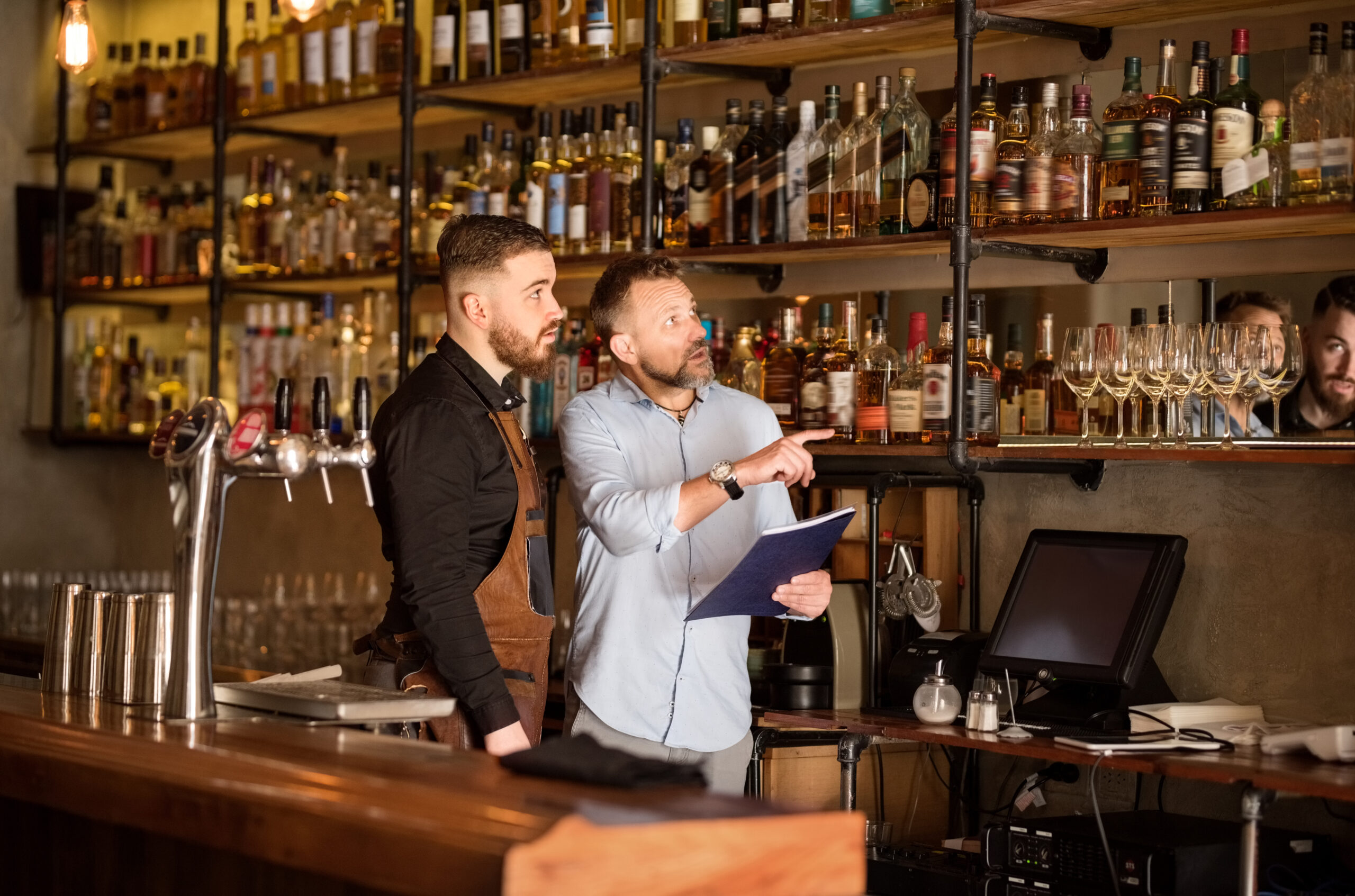 Shot of a bar manager checking the stock with bartender